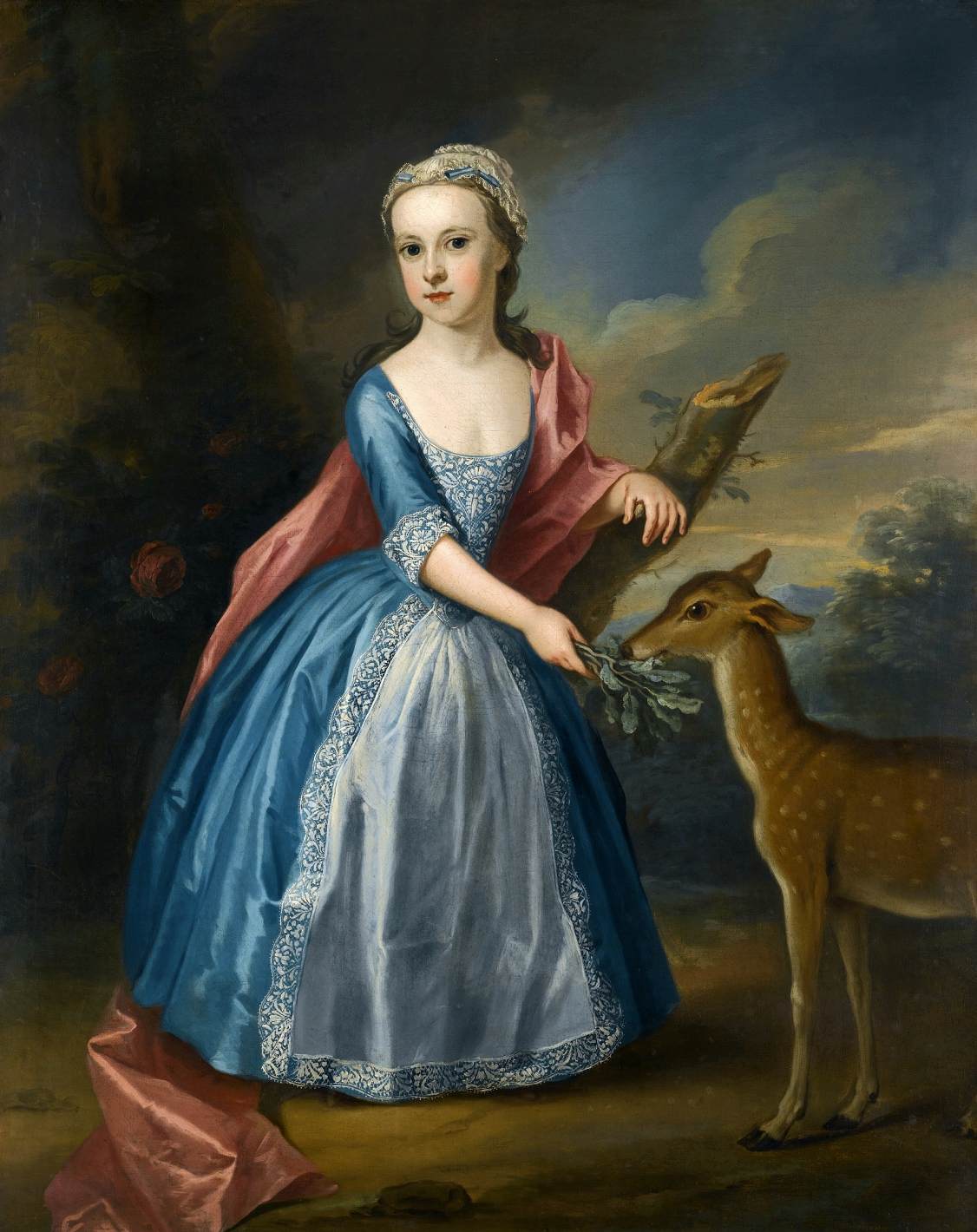 Porträt eines Mädchens, das einen Hirsch füttert